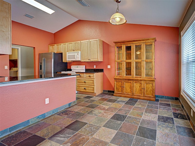 4103 Kinlock St, North Port, FL 34286 - kitchen with white appliances, stone tile floors, dark countertops, vaulted ceiling, and decorative light fixtures