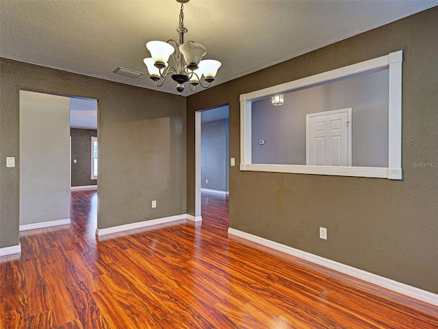4103 Kinlock St, North Port, FL 34286 - unfurnished room with a chandelier, wood finished floors, a textured ceiling, and a textured wall