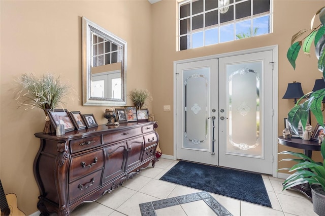 3950 Pepper Ln, North Port, FL 34287 - entrance foyer with french doors, light tile patterned flooring, a towering ceiling, and baseboards
