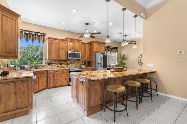 3950 Pepper Ln, North Port, FL 34287 - kitchen with stainless steel appliances, a ceiling fan, brown cabinetry, backsplash, and healthy amount of natural light