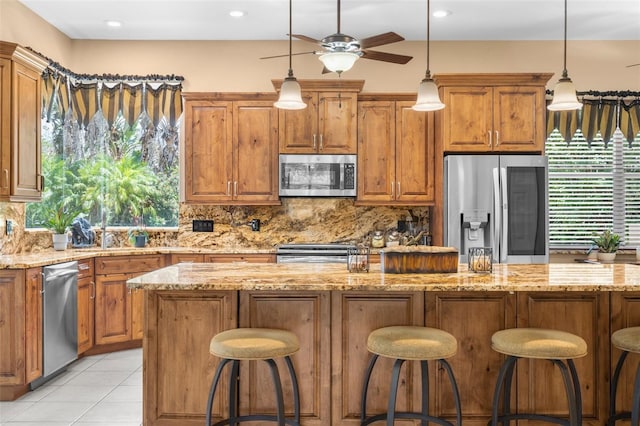 3950 Pepper Ln, North Port, FL 34287 - kitchen featuring stainless steel appliances, decorative backsplash, a ceiling fan, a sink, and pendant lighting