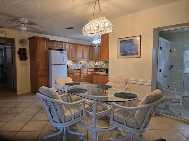 dining room with ceiling fan, light tile patterned floors, and baseboards