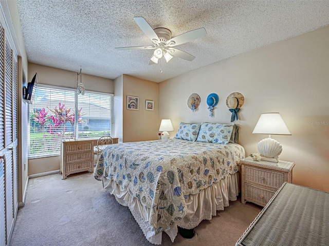 carpeted bedroom with a textured ceiling and a ceiling fan