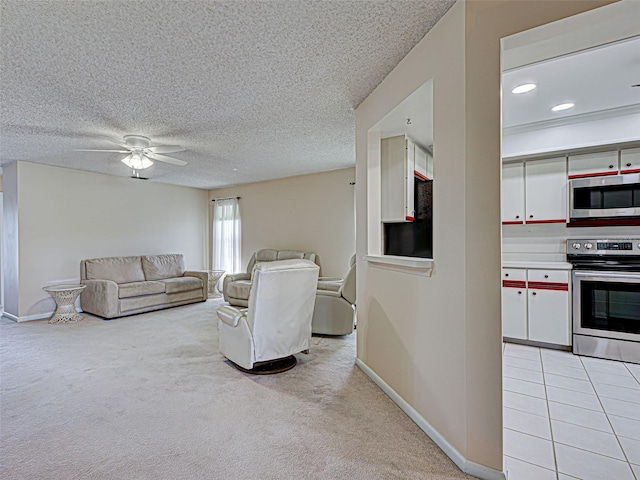 living room featuring a ceiling fan, baseboards, light carpet, and a textured ceiling