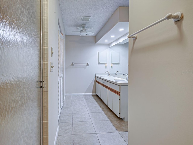 3141 Heron Shores Dr, Venice, FL 34293 - full bathroom featuring double vanity, tile patterned floors, a textured ceiling, a shower stall, and a ceiling fan
