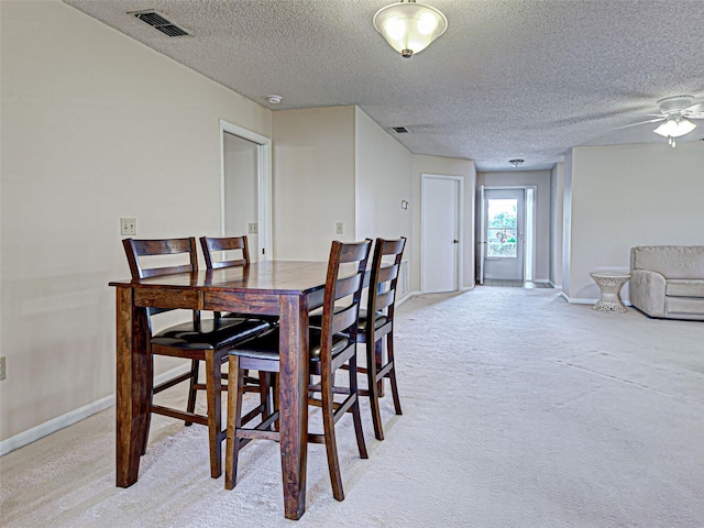 3141 Heron Shores Dr, Venice, FL 34293 - dining room featuring light colored carpet, a textured ceiling, and a ceiling fan