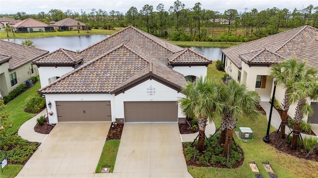 249 Tracino Ter, Nokomis, FL 34275 - view of front of home featuring driveway, a tiled roof, stucco siding, a garage, and a water view