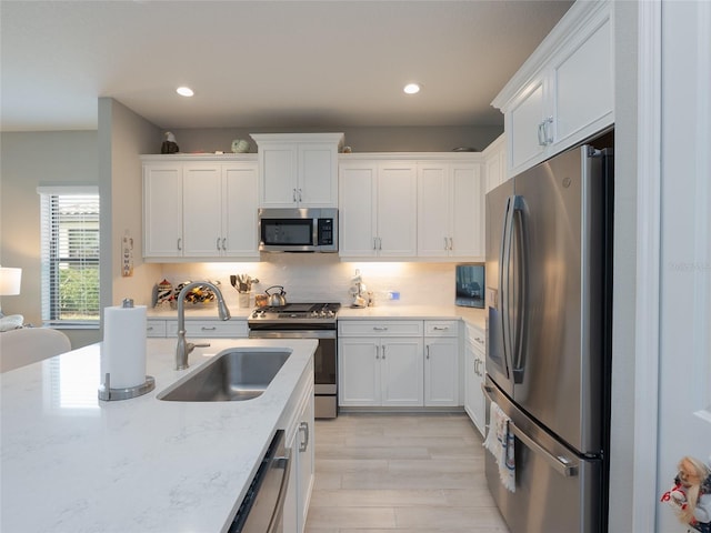249 Tracino Ter, Nokomis, FL 34275 - kitchen with stainless steel appliances, a sink, white cabinetry, light wood-style floors, and recessed lighting