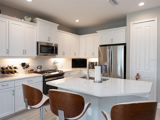 249 Tracino Ter, Nokomis, FL 34275 - kitchen featuring appliances with stainless steel finishes, a sink, white cabinetry, backsplash, and recessed lighting