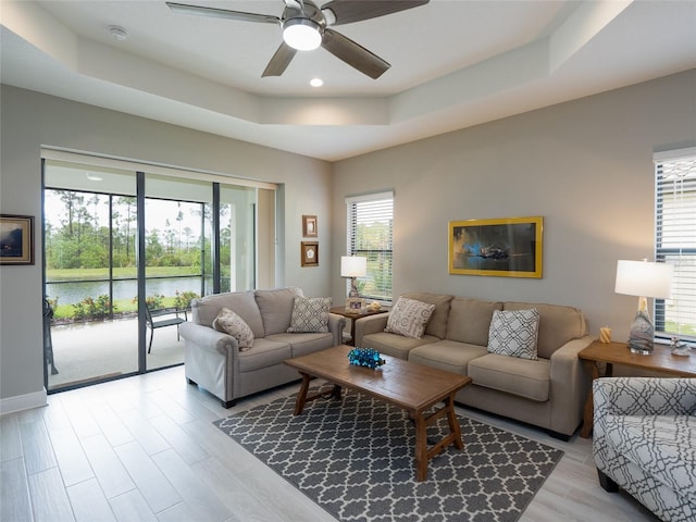 249 Tracino Ter, Nokomis, FL 34275 - living area with a tray ceiling, a ceiling fan, a water view, light wood-style floors, and recessed lighting
