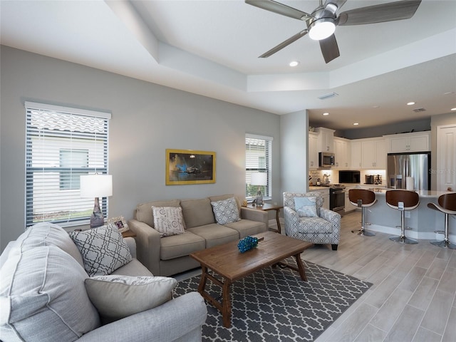 249 Tracino Ter, Nokomis, FL 34275 - living room featuring a ceiling fan, light wood-type flooring, a raised ceiling, and recessed lighting