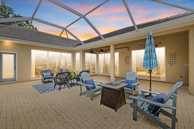 427 Autumn Chase Dr, Venice, FL 34292 - patio terrace at dusk with a fire pit, a ceiling fan, and a lanai