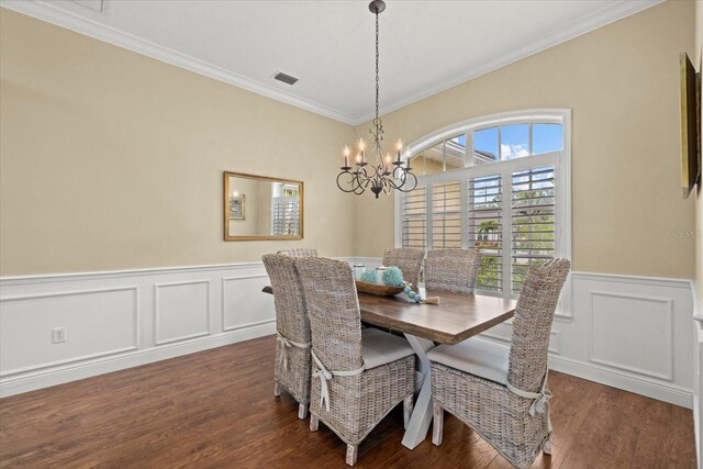 427 Autumn Chase Dr, Venice, FL 34292 - dining space featuring crown molding, a chandelier, dark wood-style floors, a wainscoted wall, and a decorative wall
