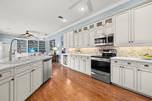 427 Autumn Chase Dr, Venice, FL 34292 - kitchen with stainless steel appliances, a ceiling fan, a sink, ornamental molding, and decorative backsplash