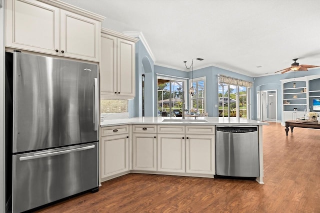 427 Autumn Chase Dr, Venice, FL 34292 - kitchen featuring appliances with stainless steel finishes, arched walkways, ceiling fan, dark wood-type flooring, and ornamental molding