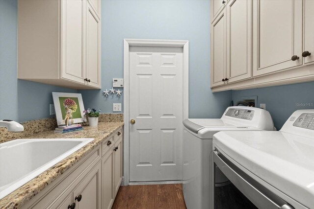 427 Autumn Chase Dr, Venice, FL 34292 - clothes washing area with washing machine and dryer, dark wood-type flooring, and cabinet space