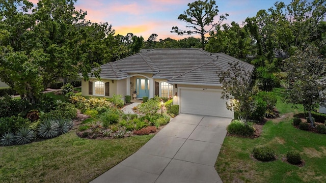 427 Autumn Chase Dr, Venice, FL 34292 - ranch-style house with stucco siding, an attached garage, concrete driveway, and a front lawn