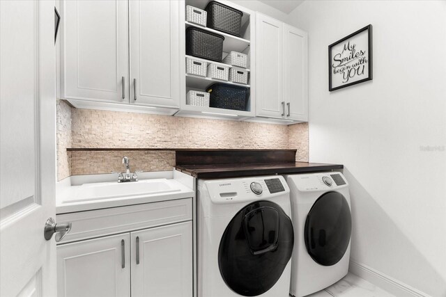 329 Myrtle Ave, Nokomis, FL 34275 - laundry area with washer and dryer, cabinet space, baseboards, and marble finish floors