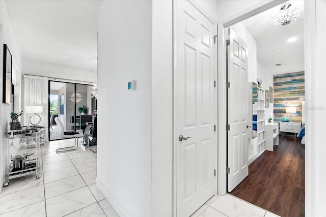 329 Myrtle Ave, Nokomis, FL 34275 - corridor featuring marble look tile flooring, baseboards, and a chandelier
