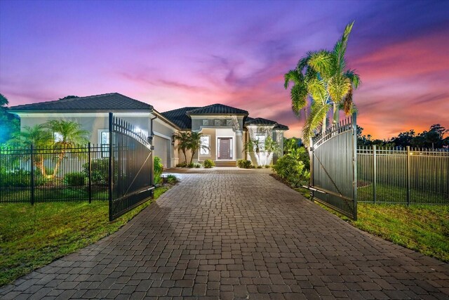 329 Myrtle Ave, Nokomis, FL 34275 - view of front facade featuring decorative driveway, an attached garage, stucco siding, and a gate