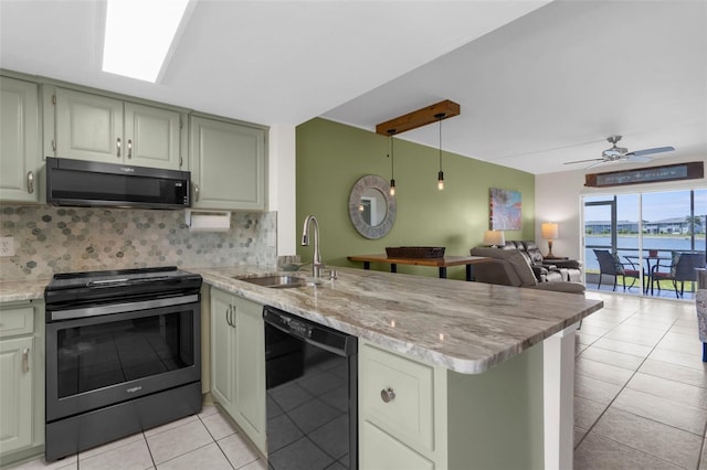 kitchen featuring electric range oven, stainless steel microwave, dishwasher, a sink, and a peninsula