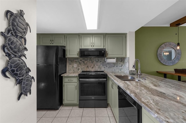 kitchen with black appliances, a sink, green cabinets, light tile patterned flooring, and light stone counters