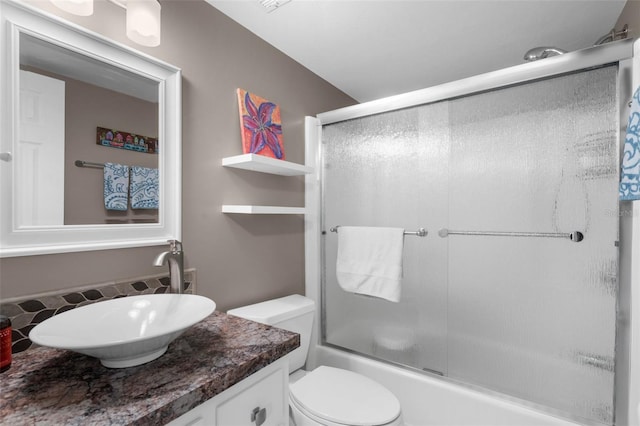full bath with vanity, toilet, and shower / bath combination with glass door