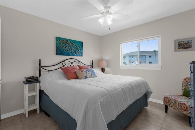 tiled bedroom featuring baseboards and ceiling fan
