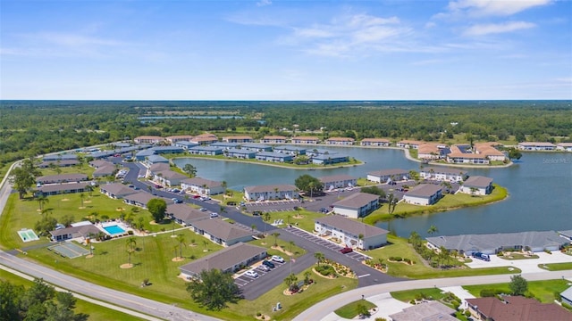 aerial overview of property's location featuring a large body of water, a heavily wooded area, and nearby suburban area