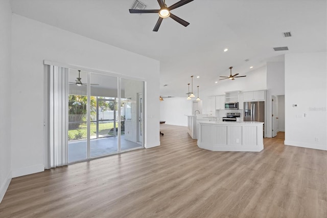 unfurnished living room with ceiling fan, light wood-style floors, recessed lighting, baseboards, and high vaulted ceiling