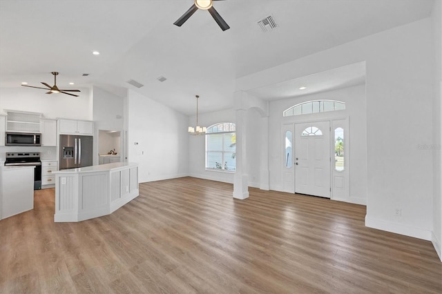 entrance foyer featuring a ceiling fan, a chandelier, baseboards, light wood-style floors, and recessed lighting