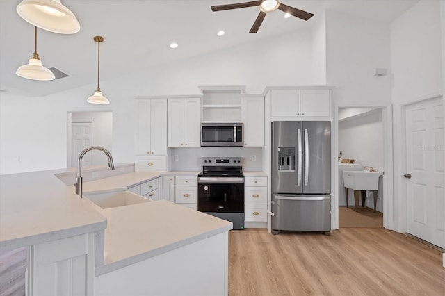 kitchen with appliances with stainless steel finishes, a sink, ceiling fan, high vaulted ceiling, and light countertops