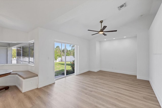 spare room with a ceiling fan, light wood-style flooring, and baseboards