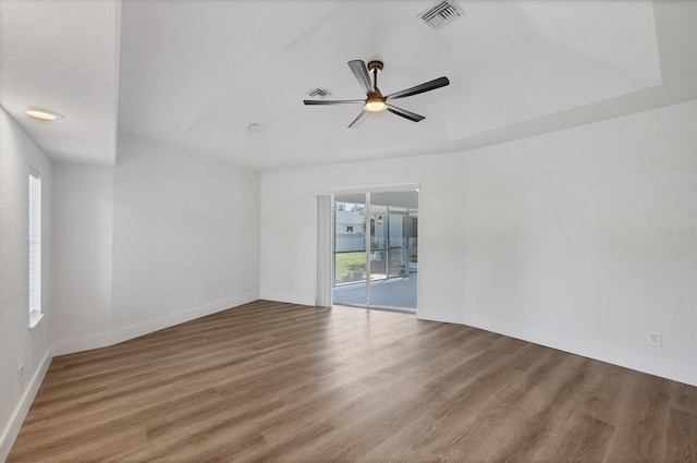 spare room featuring a ceiling fan, wood finished floors, and baseboards