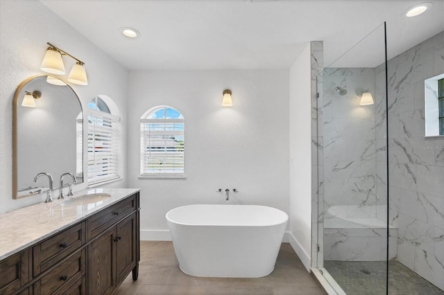 full bathroom with baseboards, a marble finish shower, vanity, a freestanding bath, and recessed lighting