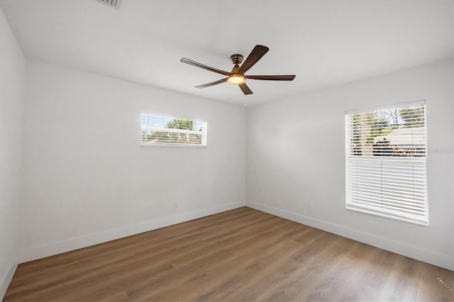 unfurnished room with light wood-style floors, ceiling fan, and baseboards
