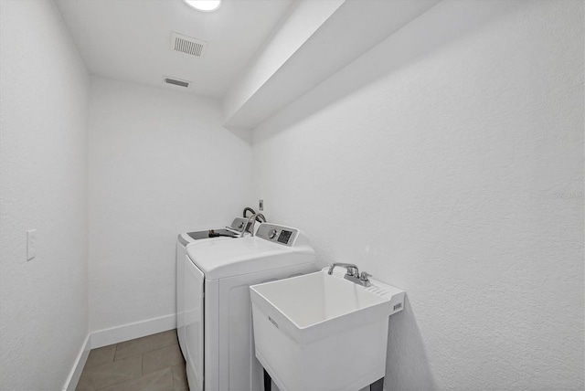 clothes washing area with baseboards and tile patterned floors