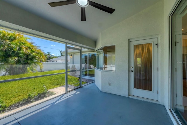 unfurnished sunroom with a ceiling fan and lofted ceiling