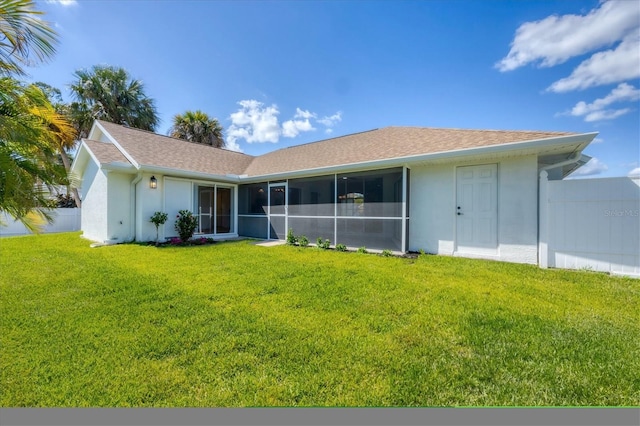 rear view of property with stucco siding, a sunroom, and a shingled roof