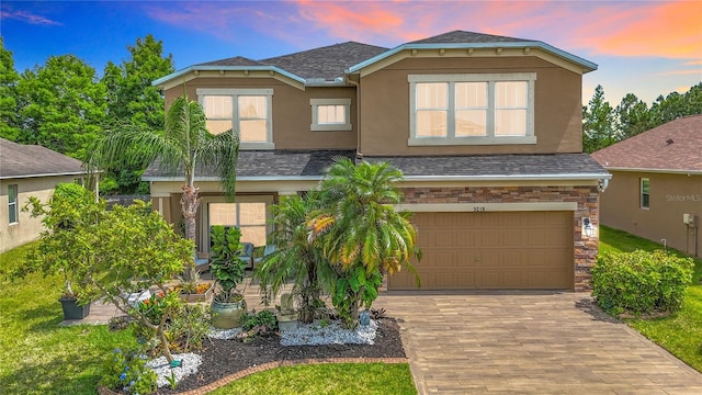 9019 39th Street Cir E, Parrish, FL 34219 - view of front of home featuring a garage, stucco siding, roof with shingles, and decorative driveway