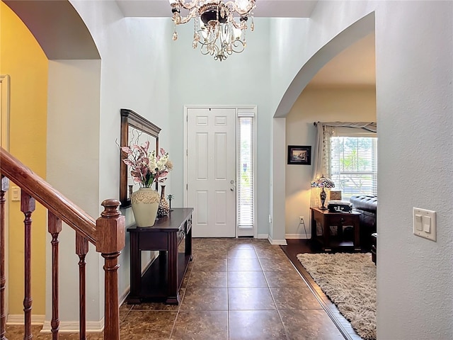 9019 39th Street Cir E, Parrish, FL 34219 - foyer with arched walkways, a chandelier, and dark tile patterned floors