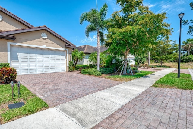 20636 Swallowtail Ct, Venice, FL 34293 - view of front of home with stucco siding, driveway, and a garage