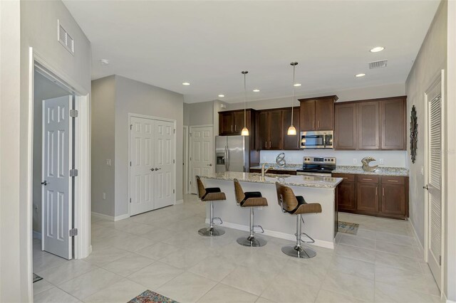 20636 Swallowtail Ct, Venice, FL 34293 - kitchen featuring appliances with stainless steel finishes, a sink, a breakfast bar, a kitchen island with sink, and recessed lighting
