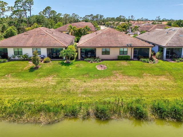 20636 Swallowtail Ct, Venice, FL 34293 - back of property with a yard, a tile roof, stucco siding, and a water view