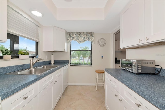 6796 Gasparilla Pines Blvd Unit 18, Englewood, FL 34224 - kitchen featuring a sink, dark countertops, a tray ceiling, and white cabinetry