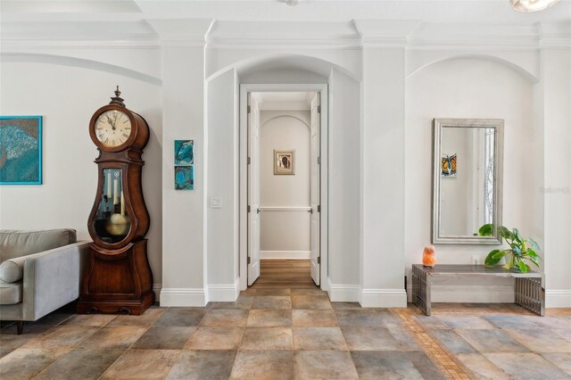 5850 Saddle Oak Trl, Sarasota, FL 34241 - hallway featuring stone tile flooring, baseboards, and crown molding