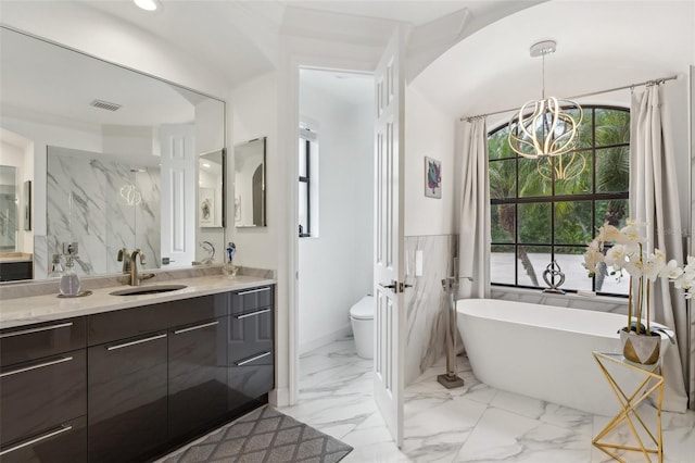 5850 Saddle Oak Trl, Sarasota, FL 34241 - bathroom with a chandelier, a freestanding tub, vanity, marble finish floors, and toilet