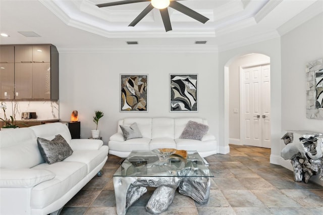 5850 Saddle Oak Trl, Sarasota, FL 34241 - living room with arched walkways, a raised ceiling, ceiling fan, ornamental molding, and baseboards