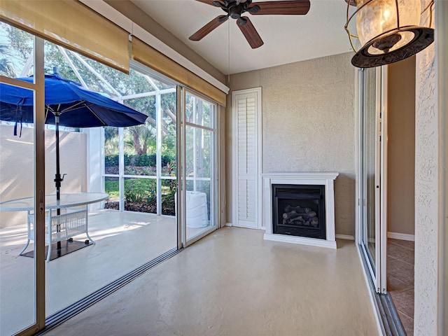 912 Barclay Ct, Venice, FL 34293 - unfurnished living room with ceiling fan, healthy amount of natural light, finished concrete flooring, a fireplace, and a textured wall