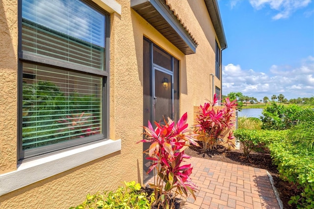 10808 Tarflower Dr Unit 102, Venice, FL 34293 - property entrance featuring stucco siding, a water view, and a patio